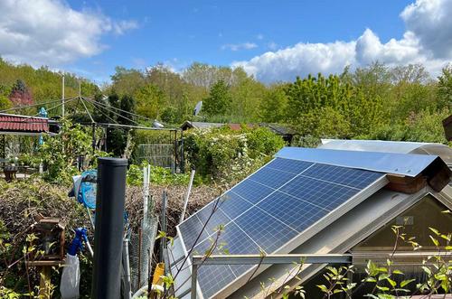 zwei Solarmodule auf einem Gewächshaus im Kleingarten