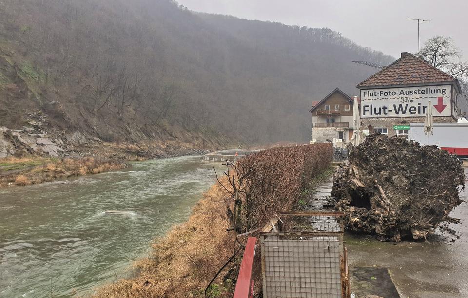 links ein Fluss, daneben ein haus auf dem "Flutwein" steht sowie "Flut-Foto-Ausstellung" und Markierung "9,24 m" 