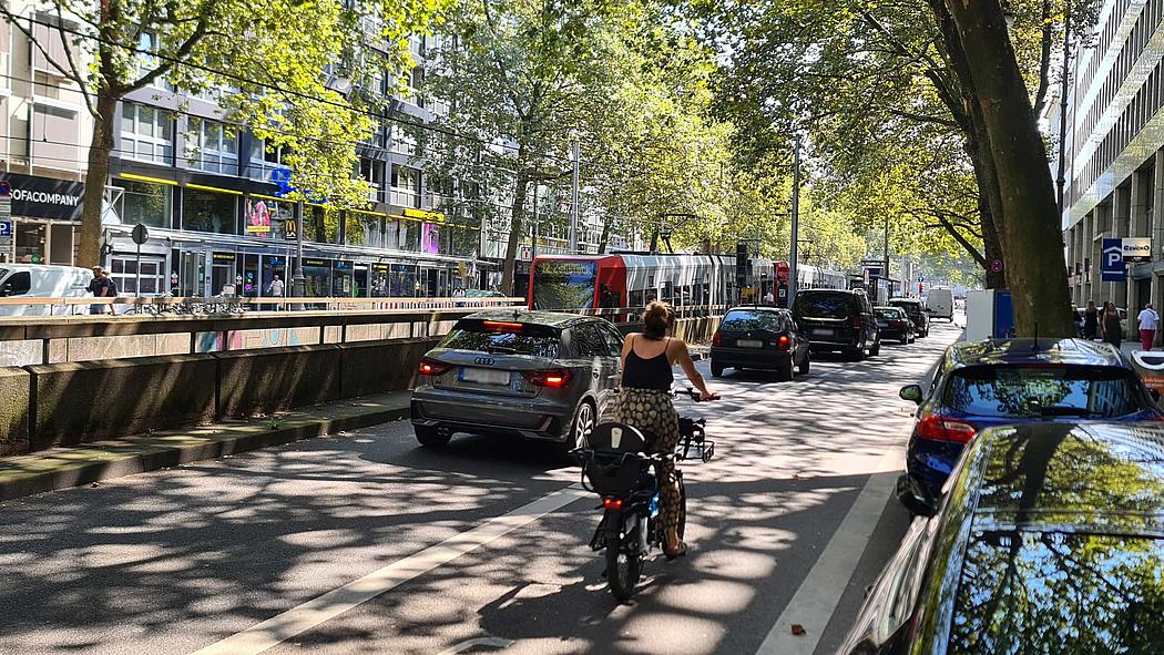 Rad- Auto- und Schienenverkehr auf einer Straße in einer Stadt