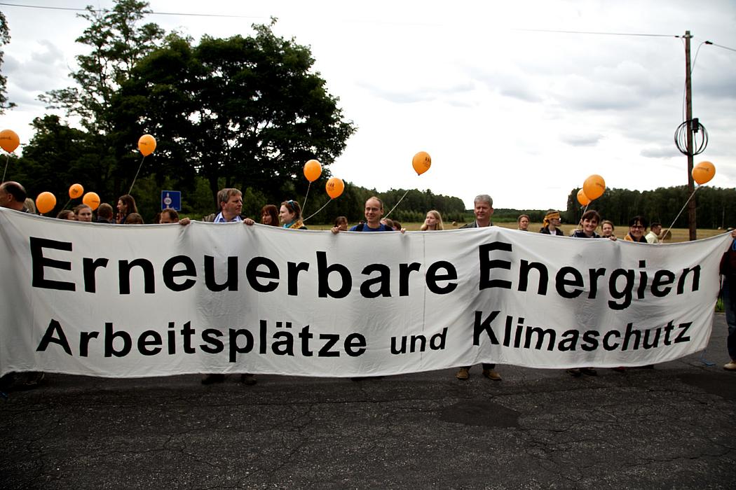 demonstrierende mit Banner. auf dem steht: Erneuerbare Energien, Arbeitsplätze und Klimaschutz