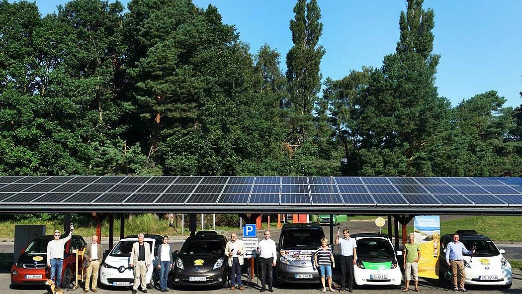 Carport mit Photovoltaik in Bansin, Elektro-Autos und Menschen