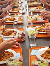 Mehrere Teller mit Spaghetti in einer Kantine