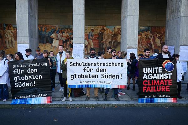 Menschen mit Plakaten vor dem Finanzministerium in Berlin