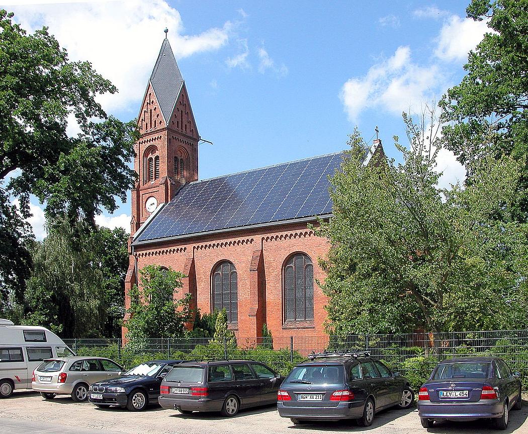 dunkle Solarmodule auf einer Backsteinkirche