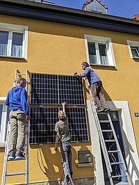 Solarmodul wird an Hauswand befestigt.