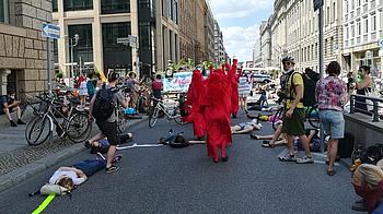 Protest vor dem VDA mit in roten Roben gekleideten Personen.