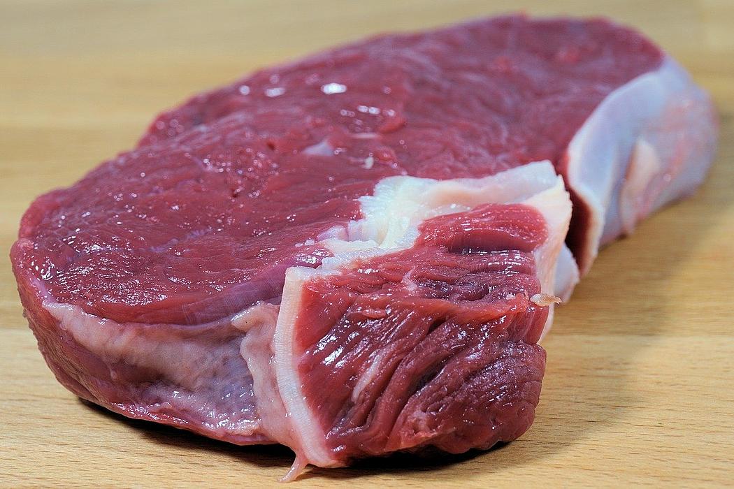 Ein Stück rohes rotes Fleisch auf Holzbrett