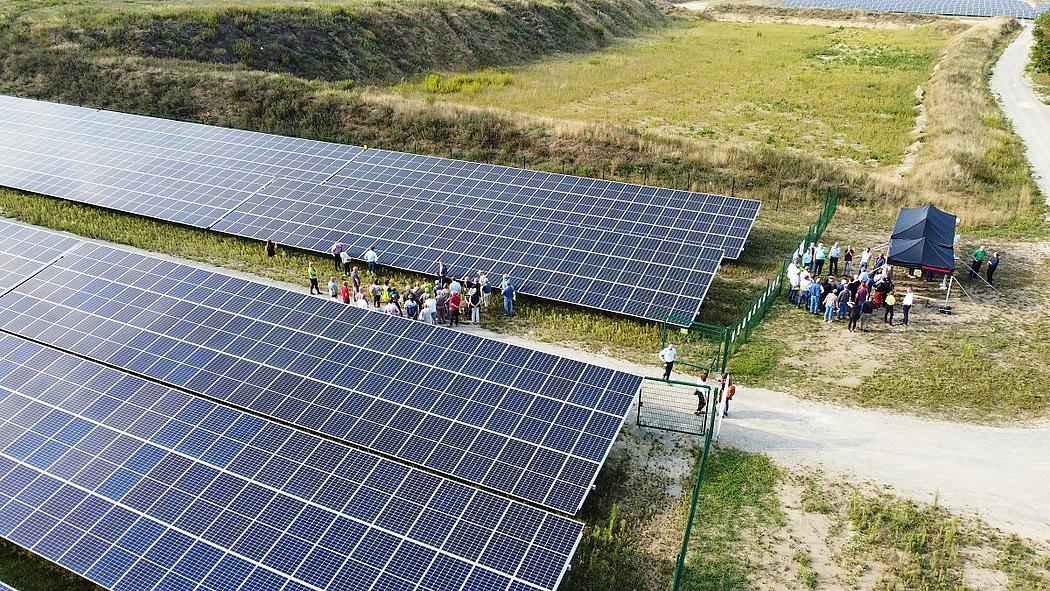 Menschen besichtigen einen Solarpark
