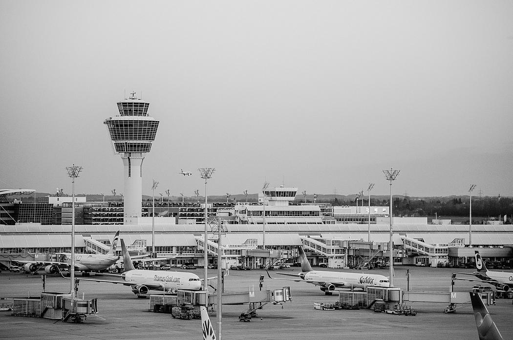 Schwarz-weiß Bild des Münchener Flughafengeländes mit Flugzeugen und Tower