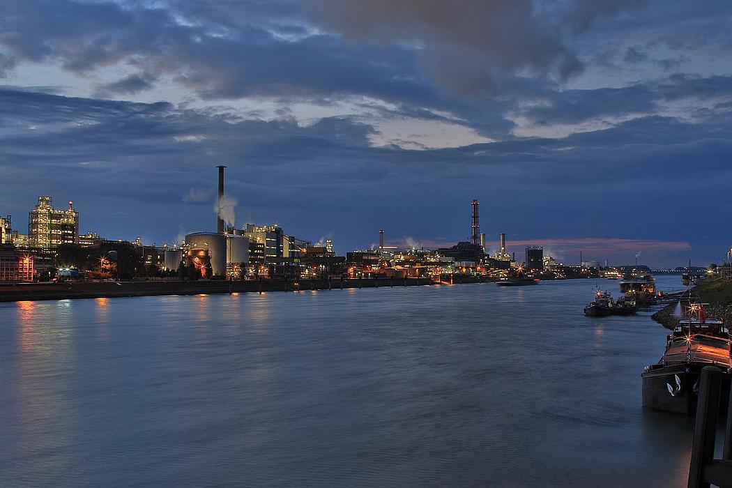 Industriebauten an einem Fluss in der Nacht