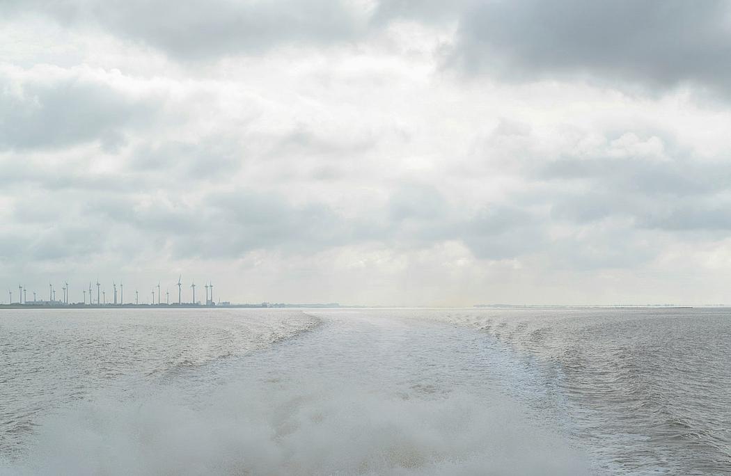 Blick auf das Wattenmeer der Nordsee mit Windenergie-Anlagen im Hintergrund