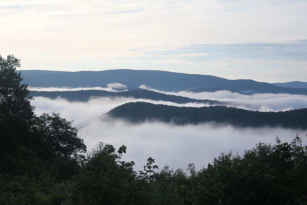 Blick von einem Berg auf eine bergige Landschaft im Nebel