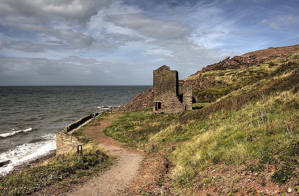 Bild einer Küste mit einer Ruine und Weg.