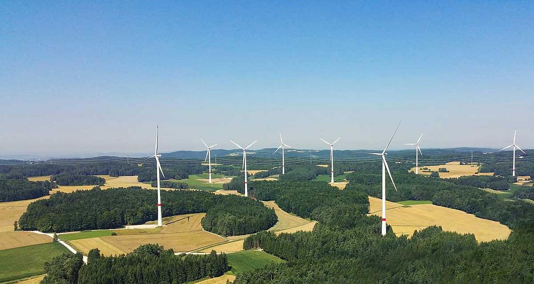 Windenergieanlagen in Landschaft mit Feldern