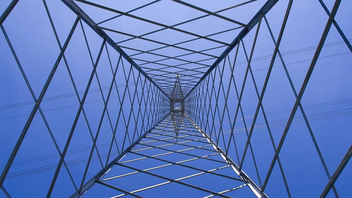 Blick von unten in einen Hochspannungsstrommast mit Gitterstruktur