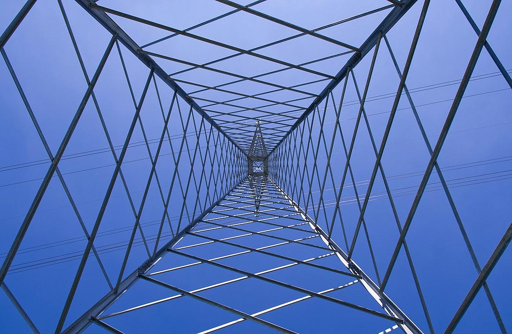 Blick von unten in einen Hochspannungsstrommast mit Gitterstruktur