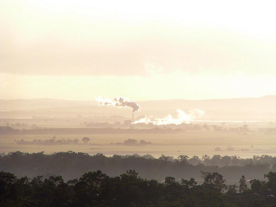 Schornstein mit Rauch in Landschaft im Morgengrauen