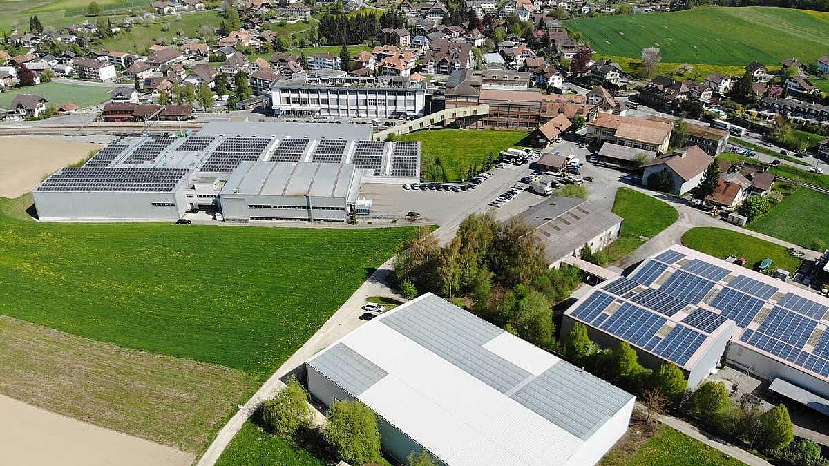 Luftaufnahme von Biglen im Kanton Bern mit mehreren Solaranlagen auf Hallendächern