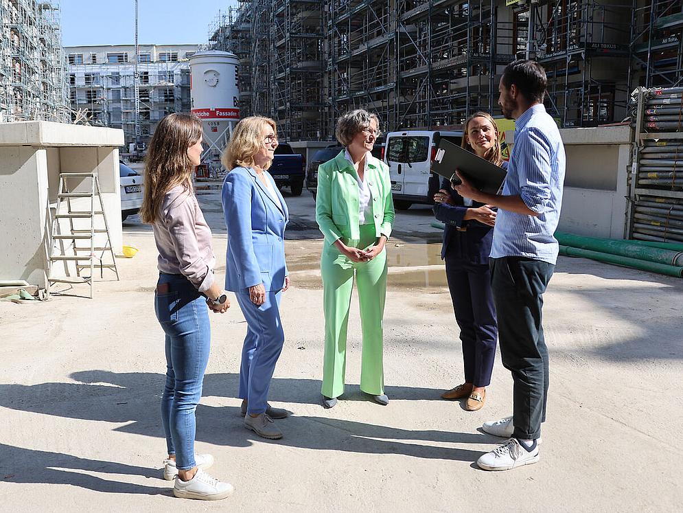 Gruppe von Menschen redet im Kreis auf einer Baustelle