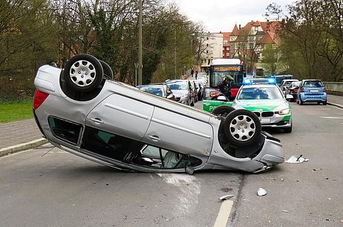 Ein silberner Pkw steht nach einem Unfall auf dem Kopf