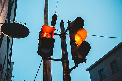 Ampel mit gelbem Licht und rote Stopp-Hand