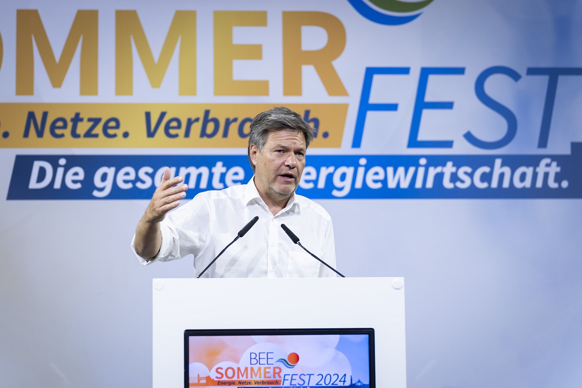 Ein Mann in weißen Hemd auf einem Podium spricht